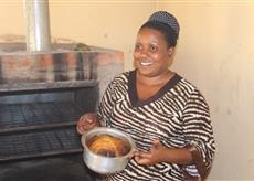 Joan baking a cake at a Women of Worth workshop.